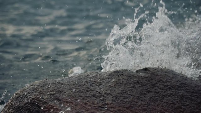 Slow motion abstract wave crashing over rock shallow depth of field video clip