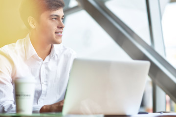 Positive young businessman using a laptop