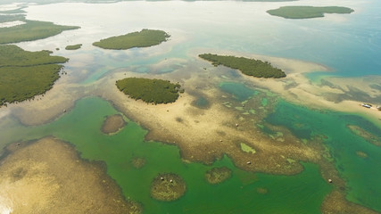 Aerial view: beach, tropical island, sea bay and lagoon, Bohol. Tropical landscape hill, clouds and mountains rocks with rainforest. Azure water of lagoon. Shore Landscape Bay. Aerial video.Seascape