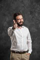Bearded happy businessman pointing to you