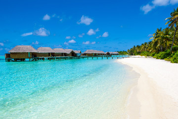 Fototapeta premium Beautiful sandy beach and over water tropical bungalo