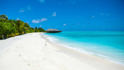 Beautiful sandy beach and over water tropical bungalo