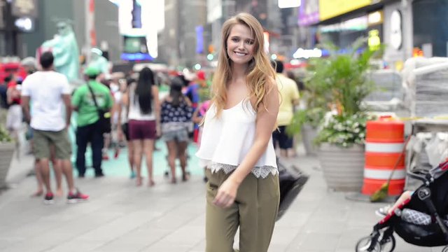Beautiful girl traveling in New York City and having fun walking and turning smiling on the crowd