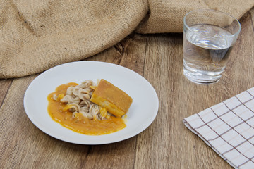 Tofu and pumpkin sauce with pasta on a table