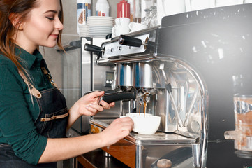 woman making coffee by coffee machine in coffee shop cafe