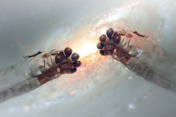 Close up of human hands touching with fingers in space. Galaxy on background. Elements of this image furnished by NASA