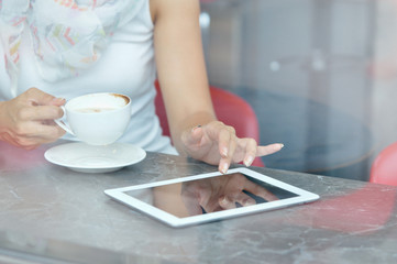 Woman use a touch pad screen while standing in cafe