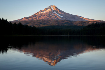 A view of a mountain over a lake at sunset