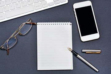 Office desk with notepad, phone and keyboard computer
