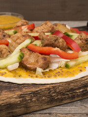 Fresh tortilla wraps with pork meat and fresh vegetables on wooden board. 