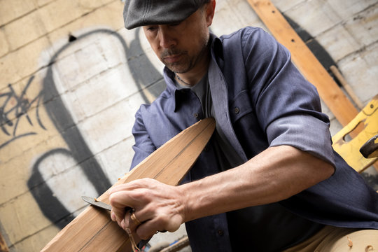 Man carving a boat oar