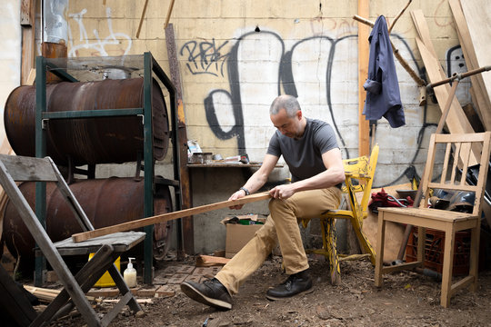 Man carving a boat oar