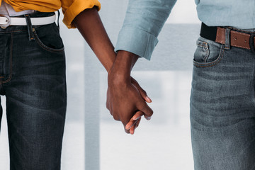 cropped image of african american couple holding hands at home - Powered by Adobe