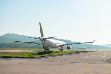 Fototapeta na wymiar Big passenger airplanes on runway strip are taxiing for take-off