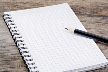 Empty notebook with pencil on table