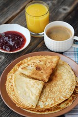 Fresh pancakes with strawberry jam, coffee and juice 