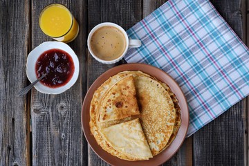 Fresh pancakes with strawberry jam, coffee and juice 