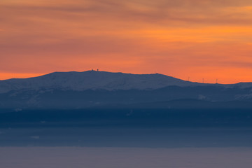 View from mountain Schoeckl over low stratus Koralpe with sunset