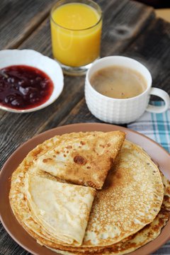 Fresh pancakes with strawberry jam, coffee and juice 