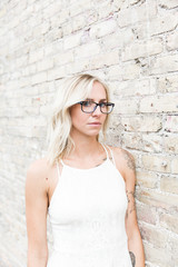 Blonde woman with brick wall backdrop