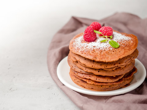 Chocolate pancakes with powdered sugar raspberry. Copy space