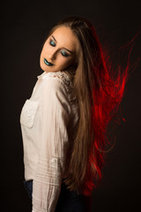 Fototapeta premium Fashionable tanned lady with wind in hair and bright creative makeup