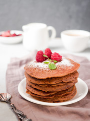 Chocolate pancakes with powdered sugar raspberry. Vertically