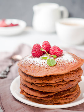 Chocolate pancakes with powdered sugar raspberry. Vertically