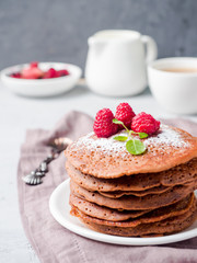 Chocolate pancakes with powdered sugar raspberry. Vertically