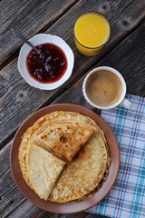 Fresh pancakes with strawberry jam, coffee and juice 