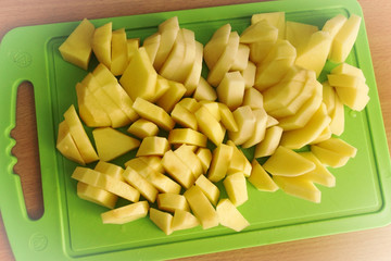 Cutting potatoes on green board