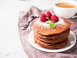 Chocolate pancakes with powdered sugar raspberry