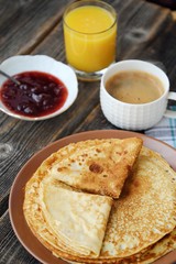 Fresh pancakes with strawberry jam, coffee and juice 
