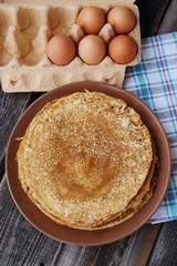 Fresh pancakes and eggs on a wooden table