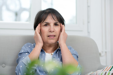 mature brunette woman with  headache at home