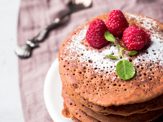 Chocolate pancakes with powdered sugar raspberry