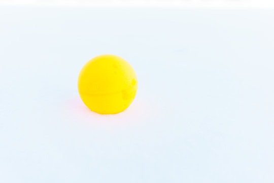Ping pong ball on the snow. Table tennis, also known as ping pong, is a sport in which two or four players hit a lightweight ball back and forth across a table using small bats