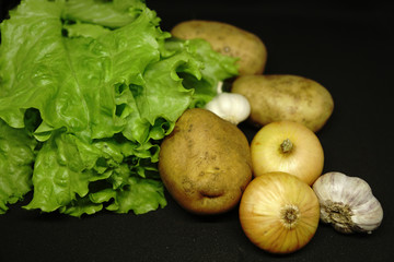 raw potatoes with onions, garlic and lettuce
