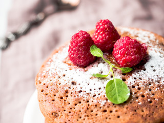 Chocolate pancakes with powdered sugar raspberry