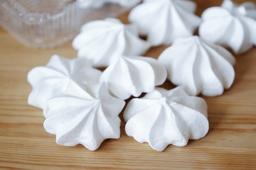 White fresh tasty meringues on wooden table 