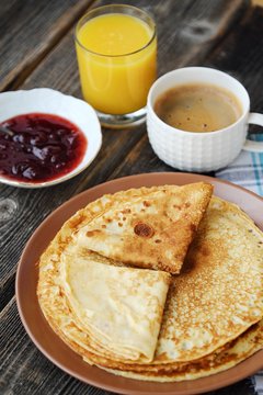 Fresh pancakes with strawberry jam, coffee and juice 