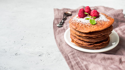 Chocolate pancakes with powdered sugar raspberry. Copy space