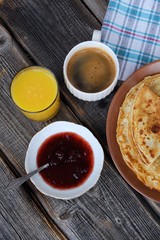 Fresh pancakes with strawberry jam, coffee and juice 