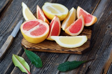 Grapefruit and lemon cut slices on grey background