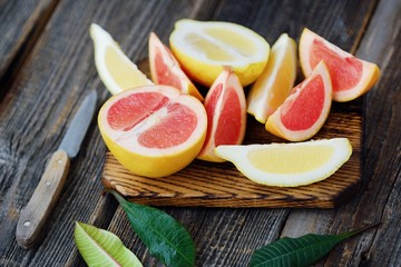 Fototapeta na wymiar Grapefruit and lemon cut slices on grey background