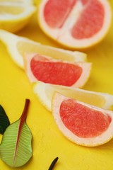 Fototapeta na wymiar Grapefruit and lemon cut slices on yellow background 