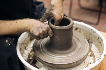 Artist makes clay pottery on a spin wheel