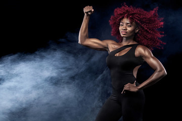 Sporty beautiful afro-american model, woman in sportwear makes fitness exercising at black background to stay fit