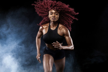 Fototapeta na wymiar A strong athletic, female sprinter, running at sunrise wearing in the sportswear, fitness and sport motivation concept with copy space.