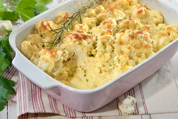 Vegetarischer Blumenkohlauflauf mit Eiern, Joghurt und Käse heiß aus dem Backofen serviert - Hearty cauliflower gratin with eggs, natural yogurt and cheese served hot from the oven